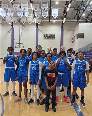 middle school basketball boys team posing together